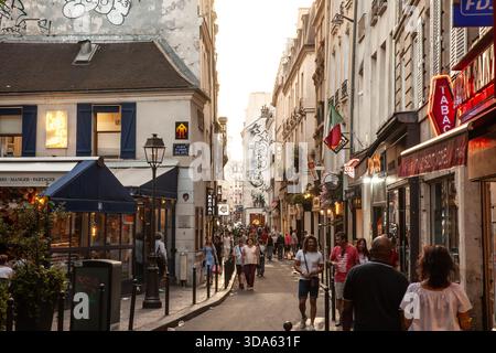 PARIS, FRANKREICH - 22. JUNI 2025: Abendszene im Pariser Viertel Le Marais, Frankreich, mit Menschenmassen, die entlang der engen Gassen spazieren Stockfoto