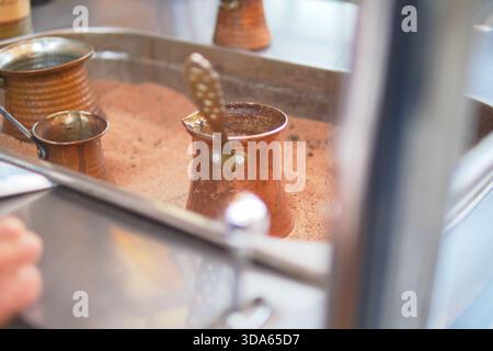türkischer Kaffee mit Kupfertöpfen in einer belebten Küche Stockfoto