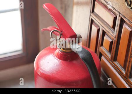 Feuerlöscher in der Nähe von Holzmöbeln in einem Raum Stockfoto