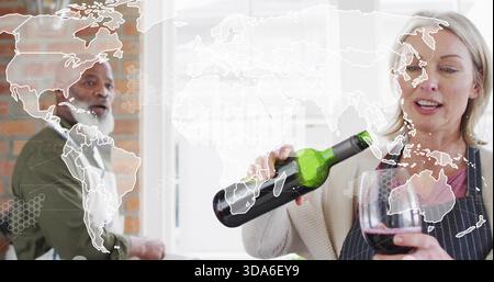 Gießende Frau füllt Weinglas mit Rotwein in der Hausküche, mit grüner Flasche und Schürzen Stockfoto