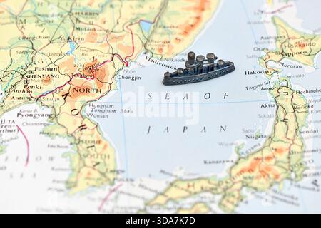 Ein Spielzeugschiff steht auf einer Karte des Japanischen Meeres und symbolisiert die Marineaktivität zwischen Japan, Korea und Russland (Wladiwostok). Stockfoto