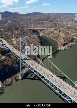 Aus der Vogelperspektive auf die Bear Mountain Bridge, die sich über den Hudson River erstreckt, mit gedämpften Brauntönen des frühen Frühlings, die auf das kühle Blau des Wassers, Bea, treffen Stockfoto
