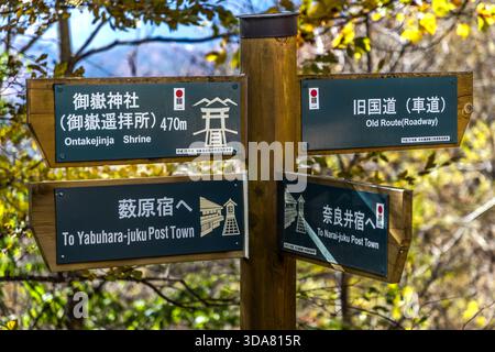 Wegweiser am Toriitoge-Pass, Nakasendo, Kiso-Tal, Präfektur Nagano, Japan: Wegbeschreibung zum Ontakejinja-Schrein (470 m), zu den Poststädten Yabuhara-juku und Narai-juku und zur alten Straßenroute. Der Pass liegt auf einer Höhe von 1197 m zwischen zwei historischen Poststationen von Nakasendo Stockfoto