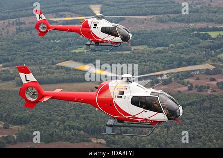 Luft-Luft-Foto von zwei HeliDax Eurocopter EC-120B Colibri Hubschraubern, die während der Sanicole Air Show in Belgien 2019 in Formation flogen. Das Bild zeigt Flugzeuge, die F-HBKL und F-HBKN in koordiniertem Flug registriert sind. Stockfoto