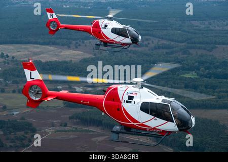Luftaufnahme zweier HeliDax Eurocopter EC-120 Colibri Hubschrauber, Variante EC-120B Calliopé, Zulassungen F-HBKL und HBKN, die während der Sanicole Air Show 2019 in Belgien in engem Formationsflug flogen. Stockfoto