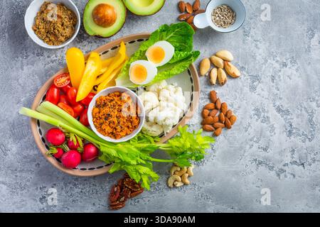 Verschiedene Snacks mit rohem Gemüse mit Karotten-Hummus und Nüssen Stockfoto