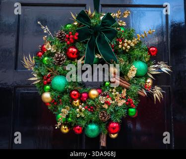 Nahaufnahme eines festlichen Weihnachtskranzes an der Haustür eines Hauses. Stockfoto