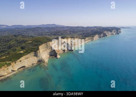 Aus der Vogelperspektive auf die dramatischen Klippen des Kap Drastis treffen auf das türkisfarbene Ionische Meer, ein atemberaubender Kontrast von Texturen und Tönen, Korfu, Griechenland. Stockfoto