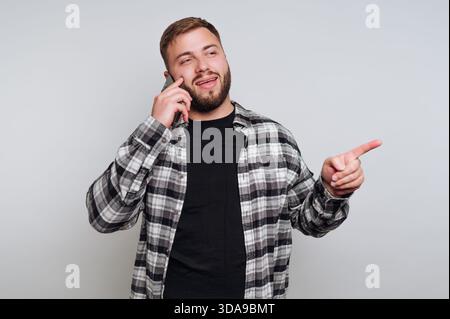 Mann in kariertem Hemd, der telefoniert und zeigt Stockfoto