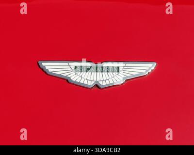 Saint Jean Cap Ferrat, Frankreich - 14. September 2025: Nahaufnahme des Aston Martin-geflügelten Logos auf einer glänzend roten Motorhaube während einer Oldtimer-Exhibitio Stockfoto