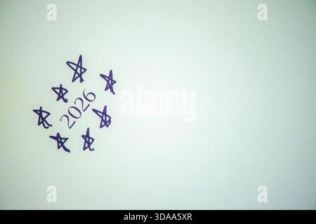 Ein sauberes und festliches Foto mit dem handgeschriebenen Satz „Happy New Year 2026“ auf weißem Hintergrund, perfekt für Weihnachtsgrüße, Karten, Banner, Stockfoto