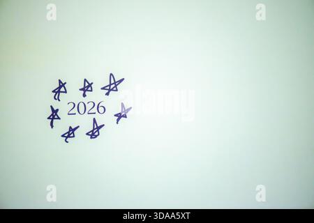 Ein sauberes und festliches Foto mit dem handgeschriebenen Satz „Happy New Year 2026“ auf weißem Hintergrund, perfekt für Weihnachtsgrüße, Karten, Banner, Stockfoto