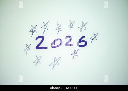 Ein sauberes und festliches Foto mit dem handgeschriebenen Satz „Happy New Year 2026“ auf weißem Hintergrund, perfekt für Weihnachtsgrüße, Karten, Banner, Stockfoto