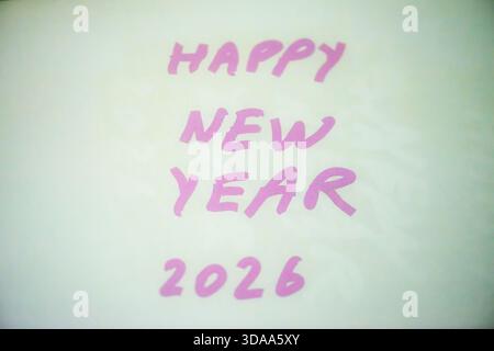 Ein sauberes und festliches Foto mit dem handgeschriebenen Satz „Happy New Year 2026“ auf weißem Hintergrund, perfekt für Weihnachtsgrüße, Karten, Banner, Stockfoto