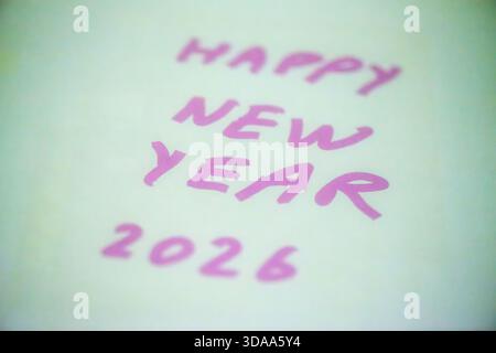 Ein sauberes und festliches Foto mit dem handgeschriebenen Satz „Happy New Year 2026“ auf weißem Hintergrund, perfekt für Weihnachtsgrüße, Karten, Banner, Stockfoto
