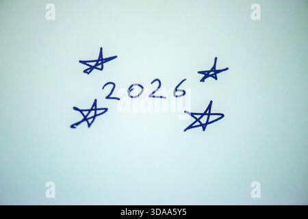 Ein sauberes und festliches Foto mit dem handgeschriebenen Satz „Happy New Year 2026“ auf weißem Hintergrund, perfekt für Weihnachtsgrüße, Karten, Banner, Stockfoto