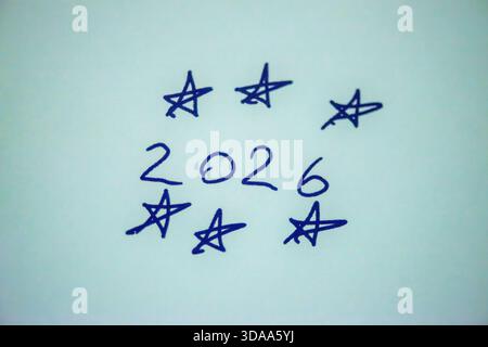 Ein sauberes und festliches Foto mit dem handgeschriebenen Satz „Happy New Year 2026“ auf weißem Hintergrund, perfekt für Weihnachtsgrüße, Karten, Banner, Stockfoto