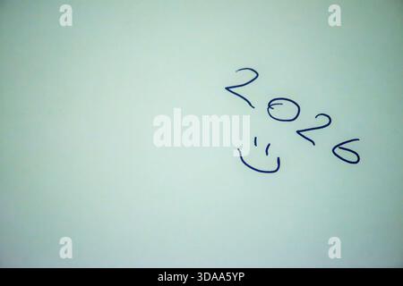 Ein sauberes und festliches Foto mit dem handgeschriebenen Satz „Happy New Year 2026“ auf weißem Hintergrund, perfekt für Weihnachtsgrüße, Karten, Banner, Stockfoto