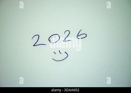 Ein sauberes und festliches Foto mit dem handgeschriebenen Satz „Happy New Year 2026“ auf weißem Hintergrund, perfekt für Weihnachtsgrüße, Karten, Banner, Stockfoto