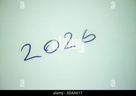 Ein sauberes und festliches Foto mit dem handgeschriebenen Satz „Happy New Year 2026“ auf weißem Hintergrund, perfekt für Weihnachtsgrüße, Karten, Banner, Stockfoto