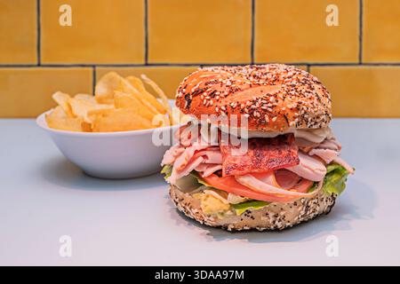 Ein Vollkornsauerteig-Bagel mit einer großzügigen Schicht Räucherlachs pâté, gekrönt mit dünnen Scheiben rohen Lachses, karamelisierten Zwiebeln und einem Tu Stockfoto