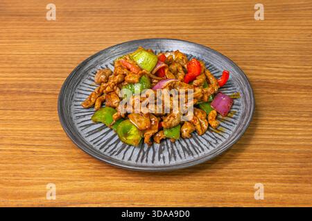 Streifen gebratener Schweinelende mit Austernsauce und gebratenem Gemüse (Karotten, Bambussprossen und Shiitake-Pilze), serviert in einer tiefen Schüssel mit Reis Stockfoto