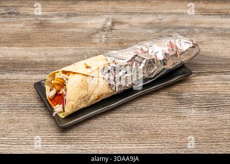 Hähnchenshawarma mit Knoblauch- und Tomatensauce, serviert mit Pommes frites und Gurkensalat Stockfoto