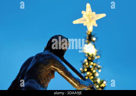 Silhouette der Neptun-Statue in Danzig mit beleuchtetem Weihnachtsbaumstern im Hintergrund Stockfoto
