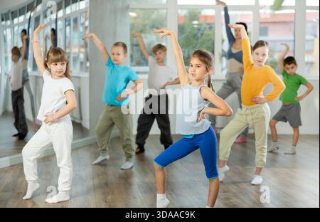 Kinder, die modernen Tanz trainieren, bewegen sich gemeinsam im Studio unter der Leitung des Lehrers Stockfoto