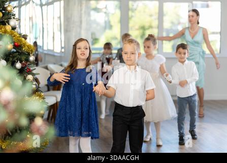 Jugendliche in eleganten Outfits üben im Weihnachtsstudio Partnertanz Stockfoto