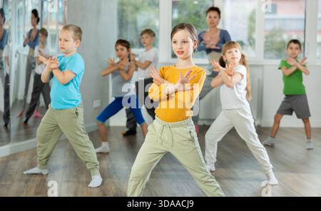 Kinder, die modernen Tanz trainieren, bewegen sich gemeinsam im Studio unter der Leitung des Lehrers Stockfoto