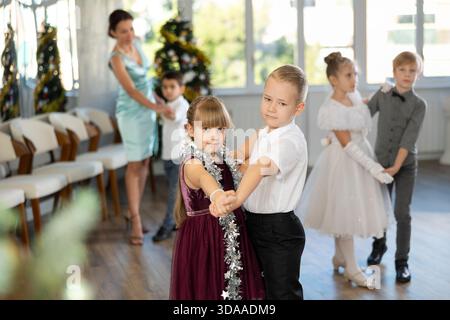 Tween Junge und Mädchen spielen Walzer während der Weihnachtsfeier in der Schule Stockfoto