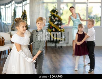 Tween Junge und Mädchen spielen Walzer während der Weihnachtsfeier in der Schule Stockfoto