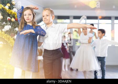 Tween Junge und Mädchen spielen Walzer während der Weihnachtsfeier in der Schule Stockfoto