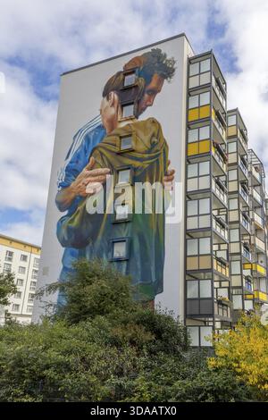 Wandgemälde, Wandträger des Street Art Artists Case Maclaim an der Wand eines achtstöckigen Gebäudes, eine junge Frau und ein Mann, der sich in der Regierungsstraße umarmt Stockfoto