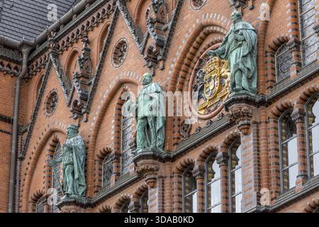Drei Bronzeskulpturen, halbrunde Fenster und rundes Wappen mit zwei Löwen und Wappen am luxuriösen Staendehaus Rostock Stockfoto