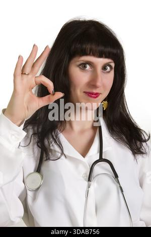 Porträt von glücklich lächelnde junge Ärztin zeigen Ordnung Geste, isoliert auf weißem Hintergrund Stockfoto