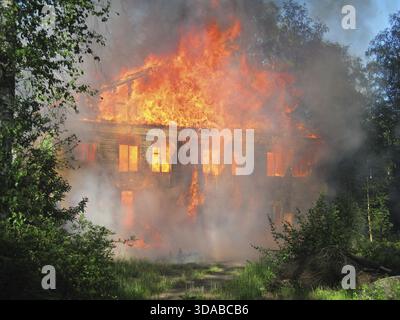 Brennendes Haus. Holzgebäude durch Feuer vollständig zerstört Stockfoto
