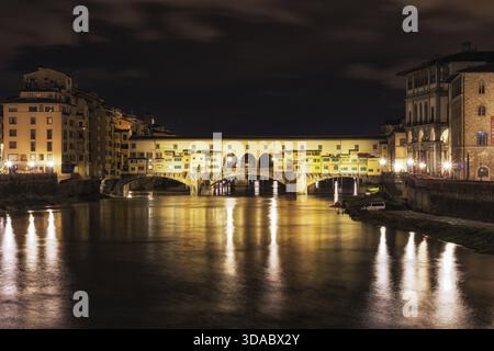 Ponte Vecchio und die Gebäude in der Nähe bei Nacht reflektieren auf dem Fluss Arno, Florenz, Italien Stockfoto