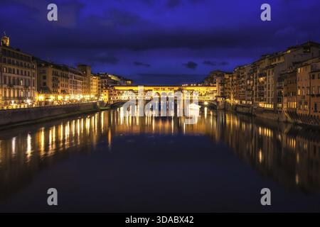 Ponte Vecchio und die Gebäude in der Nähe bei Nacht reflektieren auf dem Fluss Arno, Florenz, Italien Stockfoto