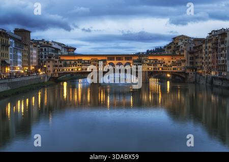 Ponte Vecchio und die Gebäude in der Nähe bei Nacht reflektieren auf dem Fluss Arno, Florenz, Italien Stockfoto