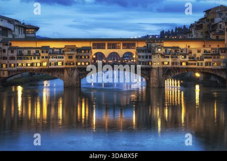 Ponte Vecchio und die Gebäude in der Nähe bei Nacht reflektieren auf dem Fluss Arno, Florenz, Italien Stockfoto