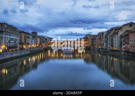 Ponte Vecchio und die Gebäude in der Nähe bei Nacht reflektieren auf dem Fluss Arno, Florenz, Italien Stockfoto