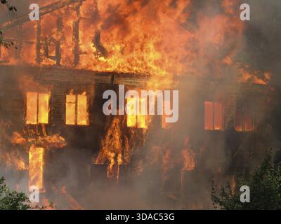 Brennendes Haus. Holzgebäude durch Feuer vollständig zerstört Stockfoto