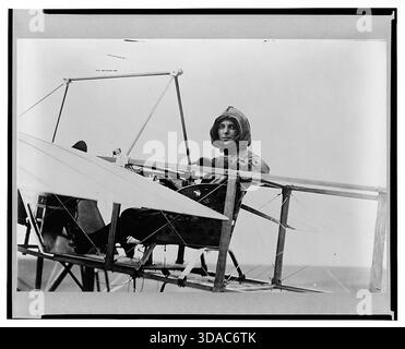 Historisches Vintage-Foto von Harriet Quimby, der im Cockpit eines frühen Doppeldeckers saß und während der Pionierzeit der Luftfahrt 1911 Flugausrüstung trug. Stockfoto