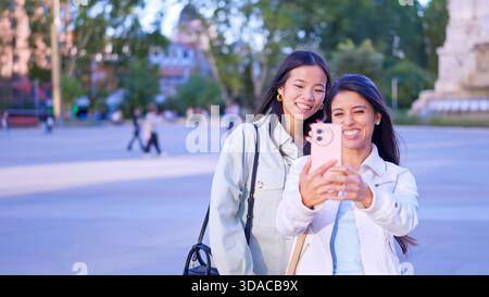 Verschiedene junge Frauen machen gemeinsam Selfie im Freien Stockfoto