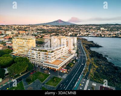 Blick aus der Vogelperspektive auf die Küste von Catania mit modernen Gebäuden und den Ätna bei Sonnenuntergang Stockfoto