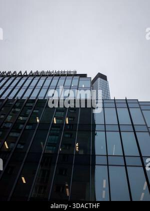Flacher Blick auf ein modernes Büro-Hochhaus aus Glas mit reflektierender Fassade in Warschau, Polen. Stockfoto