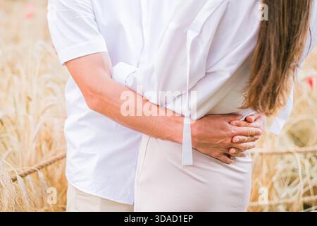 Moskau, Russland, 24.07.2022 Ein Mann und eine Frau in weißen Hemden, die sich eng umarmen. Nahaufnahme der Hände von Männern und Frauen. Warmes Licht und r Stockfoto