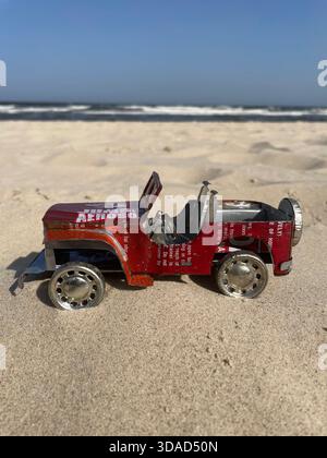 Ein lebendiger, handgefertigter Spielzeug-Jeep, der aus recycelten Soda-Dosen gefertigt wurde, fährt mit unaufhaltsamem Inselgeist an den Sandstränden Madagaskars! Willy Matheisl Stockfoto